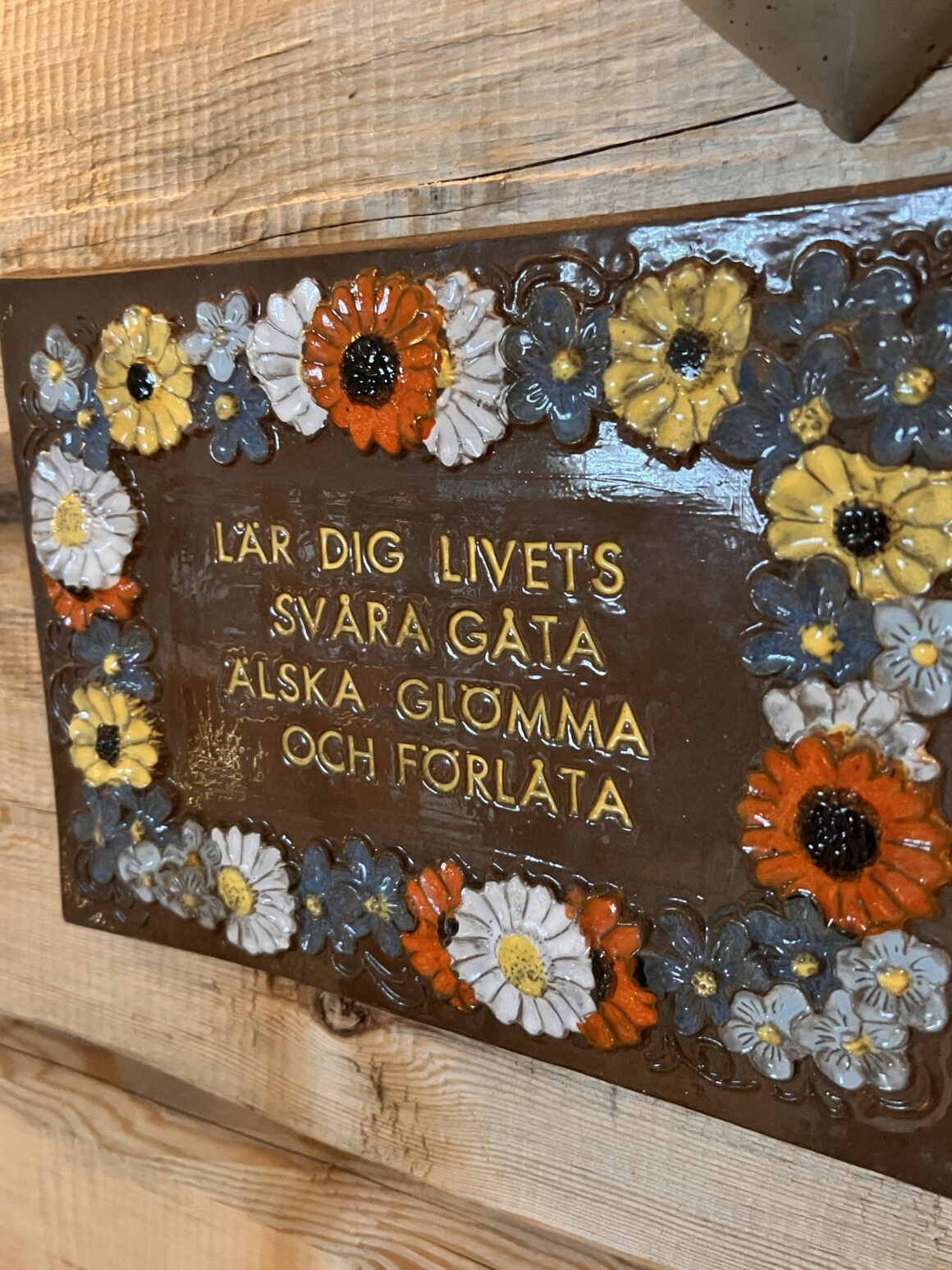 lär dig livets svåra gåta älska glömma och förlåta. Keramiktavla i butik i Vemdalen.