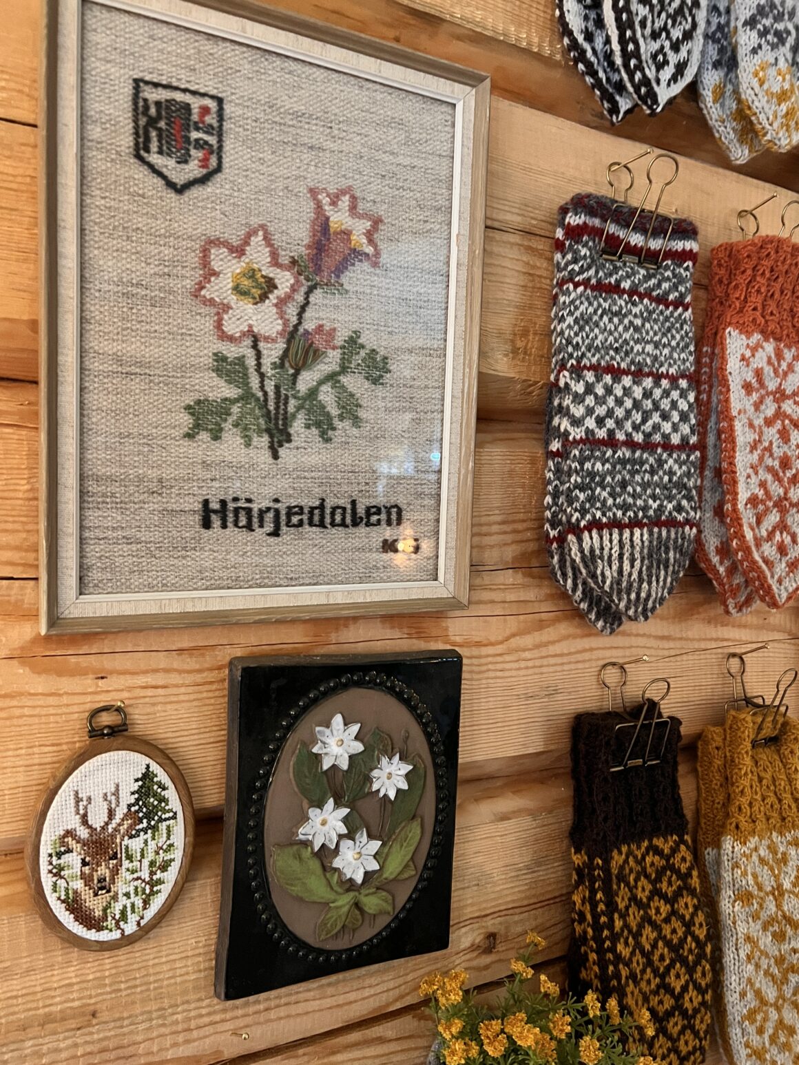 hemstickade vantar i butiken Nästgårds i vemdalen blandas med loppisfyndade vackra tavlor.